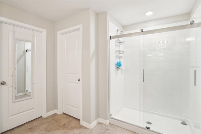 bathroom featuring tile patterned flooring and a shower with shower door