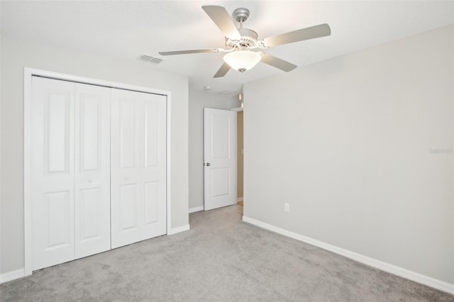 unfurnished bedroom with light colored carpet, ceiling fan, and a closet