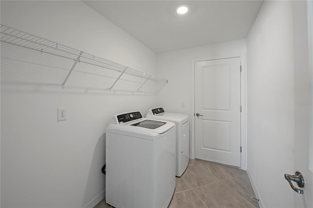 laundry room with washer and clothes dryer and light tile patterned floors