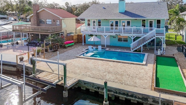 view of pool with a dock, a deck, and a patio area