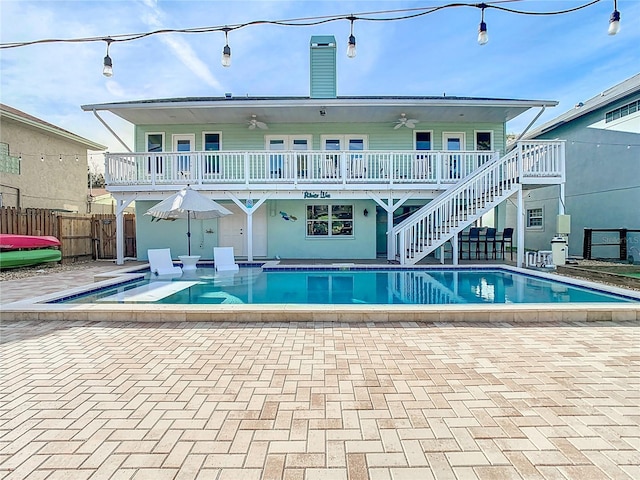 rear view of property with a fenced in pool, ceiling fan, and a patio area