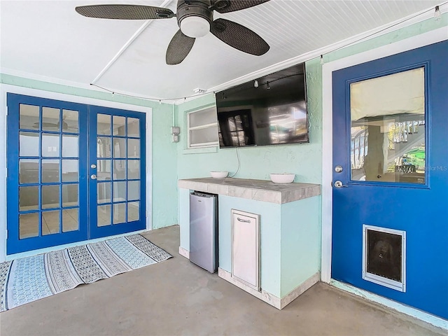 kitchen with french doors, concrete floors, fridge, and ceiling fan