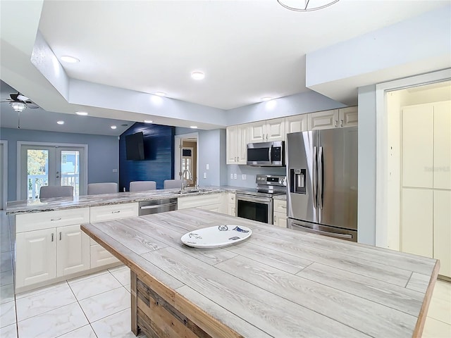 kitchen with french doors, sink, ceiling fan, kitchen peninsula, and stainless steel appliances