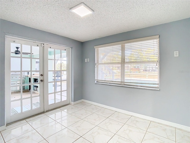 entryway with ceiling fan, a textured ceiling, and french doors