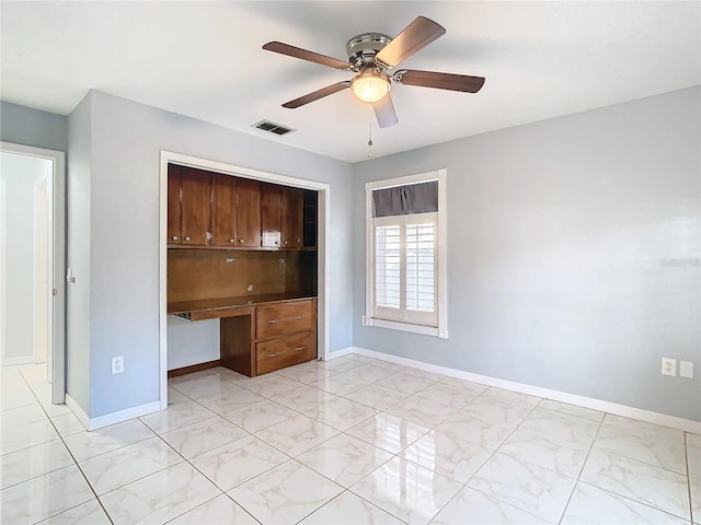 unfurnished bedroom with ceiling fan, a closet, and built in desk