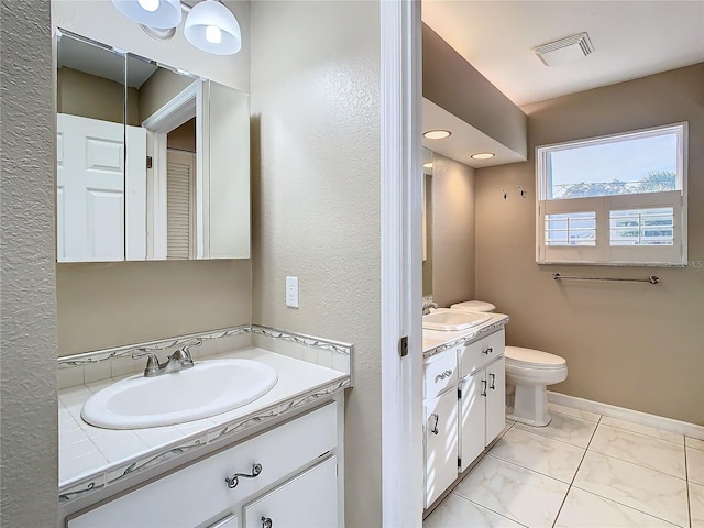 bathroom featuring tile patterned floors, vanity, and toilet