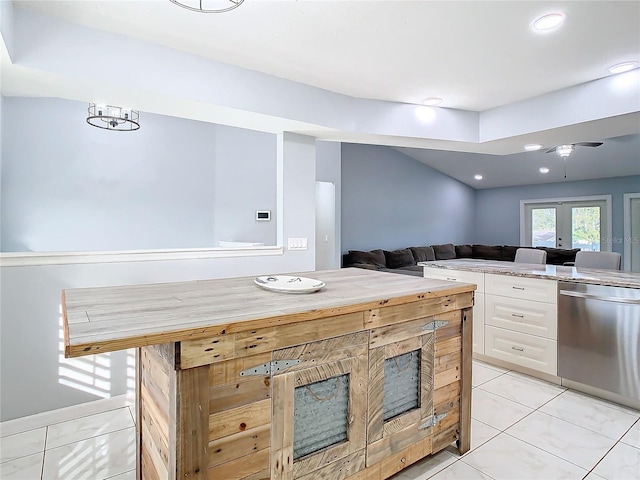 kitchen featuring french doors, stainless steel dishwasher, a center island, white cabinetry, and light tile patterned flooring