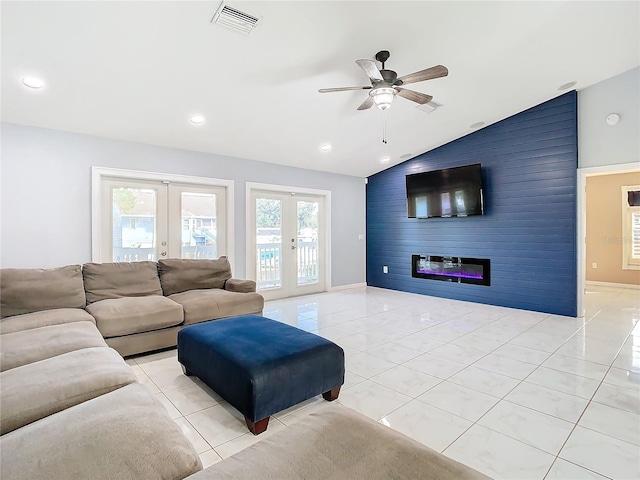 living room featuring light tile patterned flooring, lofted ceiling, french doors, ceiling fan, and a large fireplace