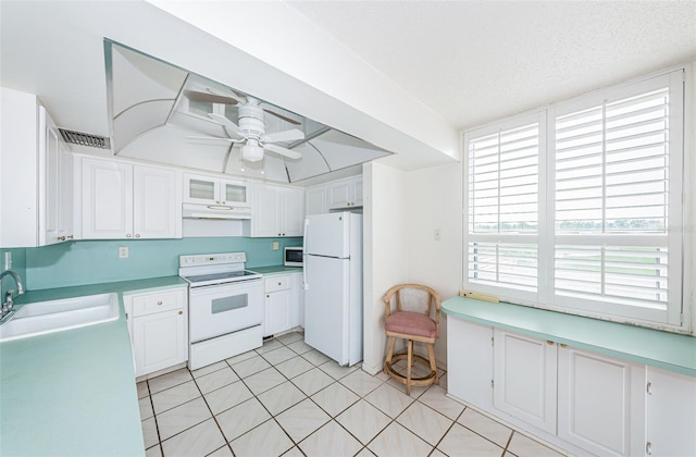 kitchen featuring white appliances, white cabinets, sink, ceiling fan, and a textured ceiling