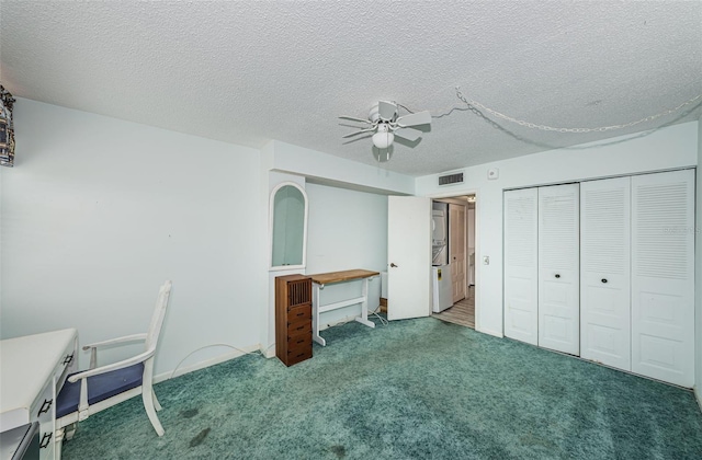 unfurnished bedroom with a textured ceiling, a closet, dark carpet, and ceiling fan