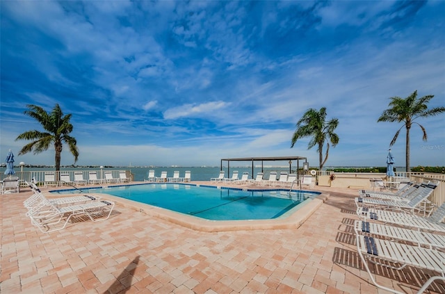 view of pool with a patio area and a water view