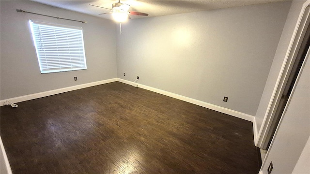 empty room featuring ceiling fan and dark wood-type flooring