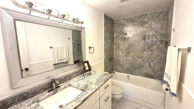 full bathroom with toilet, vanity, and tiled shower / bath