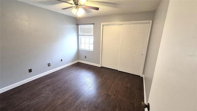 unfurnished bedroom featuring a textured ceiling, dark hardwood / wood-style flooring, a closet, and ceiling fan