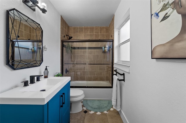 full bathroom featuring toilet, vanity, tile patterned floors, and shower / bath combination with glass door