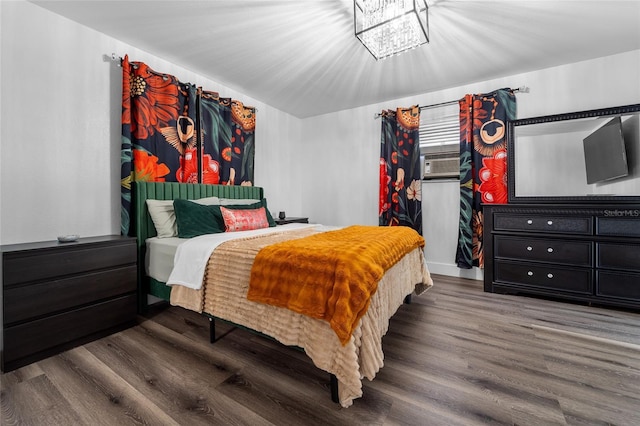 bedroom featuring dark hardwood / wood-style flooring and a chandelier