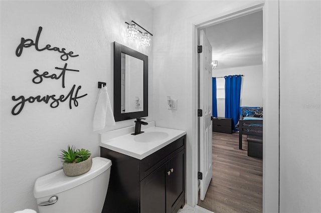 bathroom with toilet, vanity, and hardwood / wood-style floors