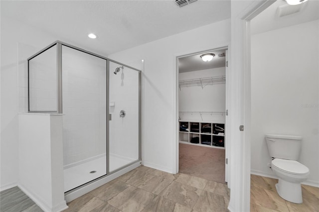 bathroom featuring toilet and walk in shower