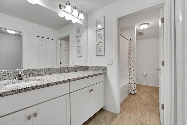 bathroom featuring vanity, shower / bathtub combination with curtain, and a textured ceiling