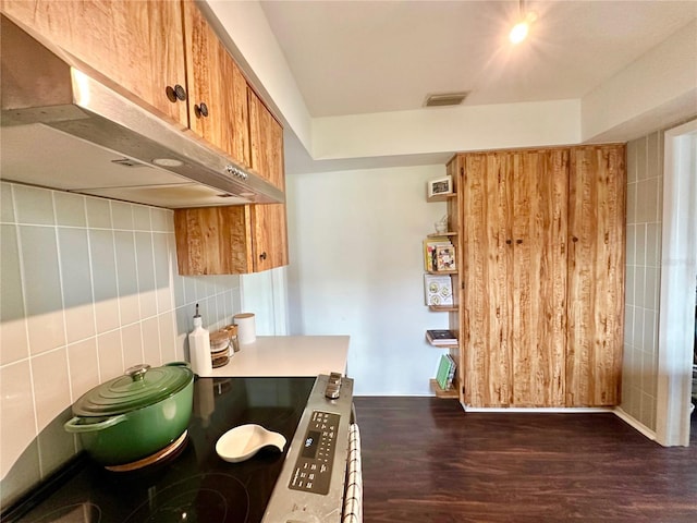 kitchen with tile walls, dark hardwood / wood-style flooring, extractor fan, and stove