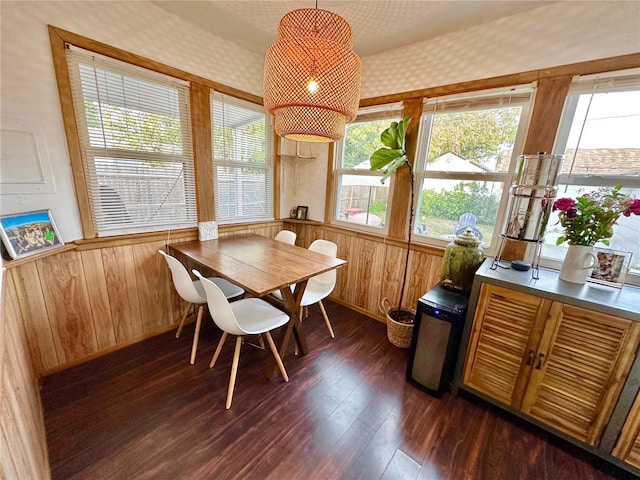 dining area featuring dark hardwood / wood-style flooring and wooden walls