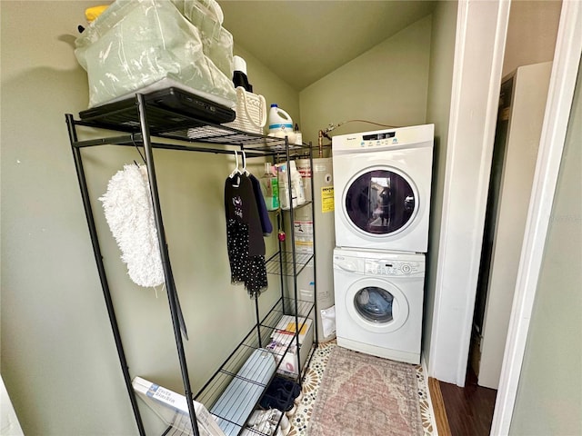 laundry room with hardwood / wood-style floors and stacked washer / dryer