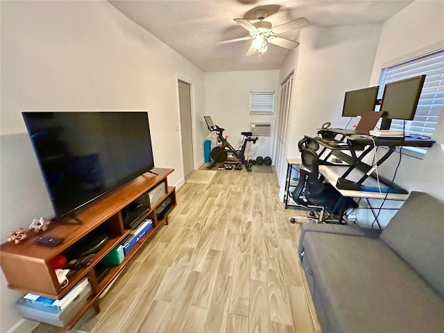 exercise area with ceiling fan and light hardwood / wood-style floors