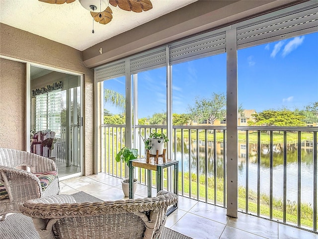 sunroom / solarium featuring a water view, ceiling fan, and a healthy amount of sunlight