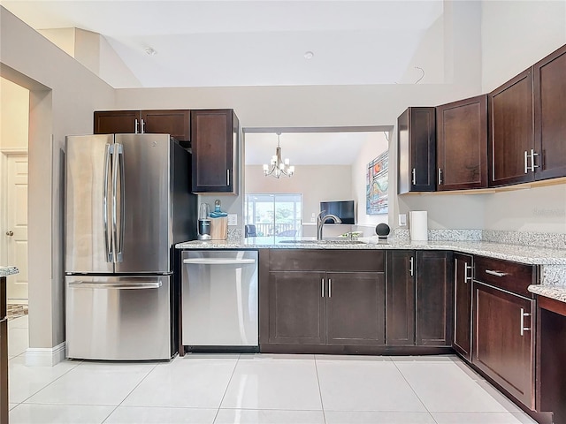 kitchen featuring appliances with stainless steel finishes, light tile patterned floors, an inviting chandelier, and light stone counters