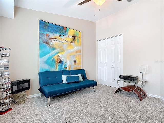 living area with carpet and ceiling fan