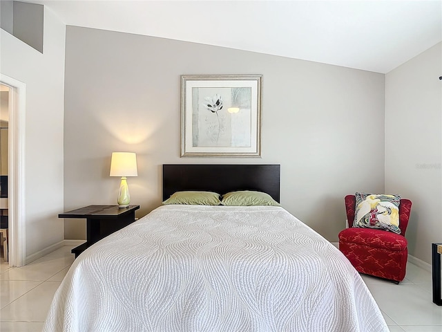 tiled bedroom featuring vaulted ceiling