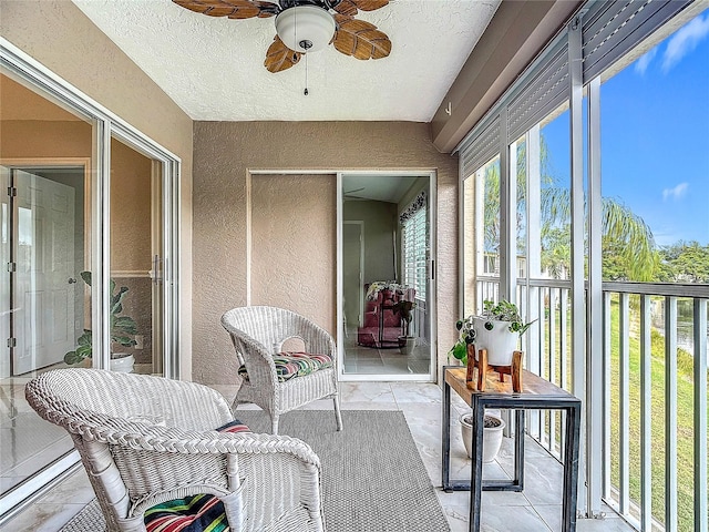 sunroom / solarium featuring ceiling fan