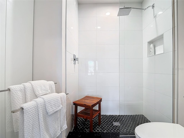 bathroom with toilet and tiled shower