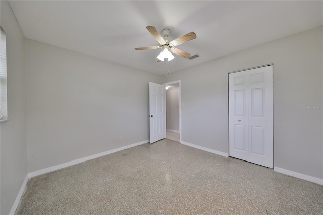 unfurnished bedroom featuring ceiling fan and a closet