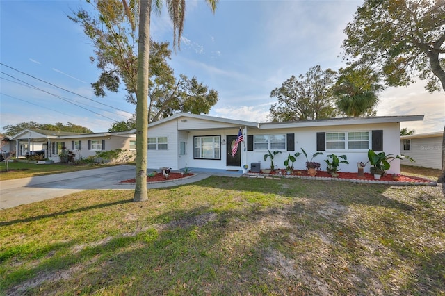 ranch-style home featuring a front lawn, driveway, and stucco siding