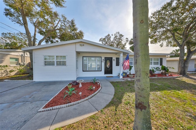 bungalow-style house featuring concrete driveway and a front yard