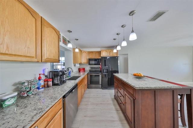 kitchen featuring black appliances, visible vents, light stone counters, and a sink