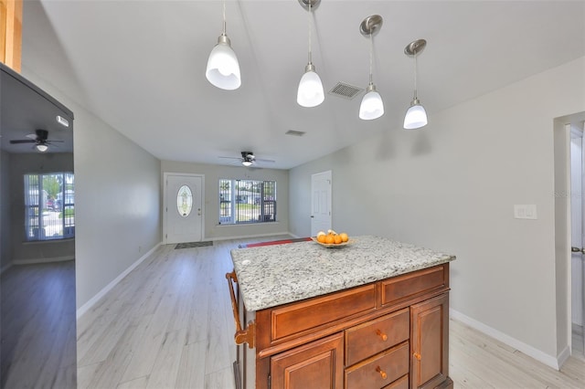 kitchen featuring light wood finished floors, a ceiling fan, visible vents, and open floor plan