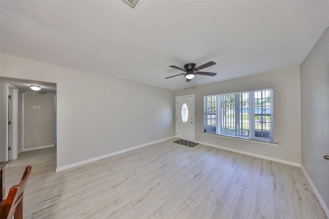 unfurnished living room with baseboards, a ceiling fan, and light wood-style flooring