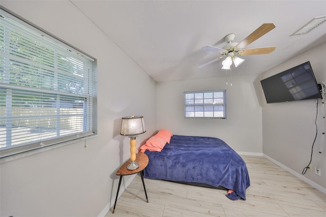 bedroom featuring baseboards, visible vents, wood finished floors, and a ceiling fan