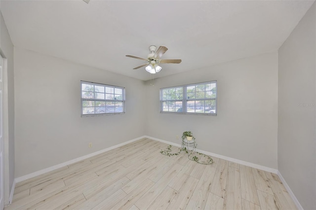 unfurnished room featuring wood finished floors, a ceiling fan, and baseboards