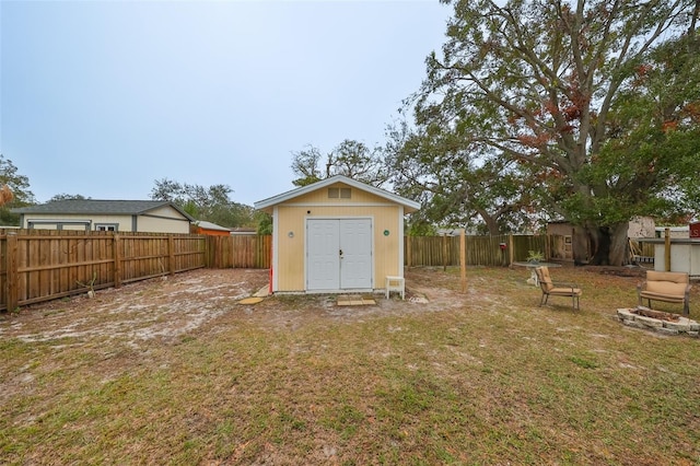 view of yard with an outbuilding, a shed, and a fenced backyard