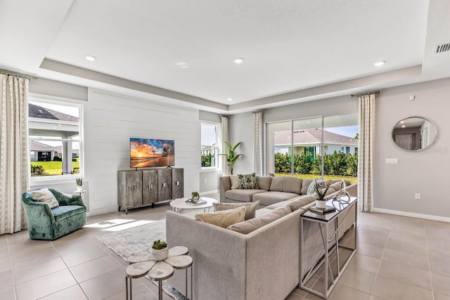 tiled living room featuring a raised ceiling