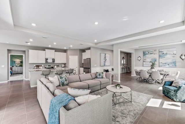 tiled living room featuring a tray ceiling