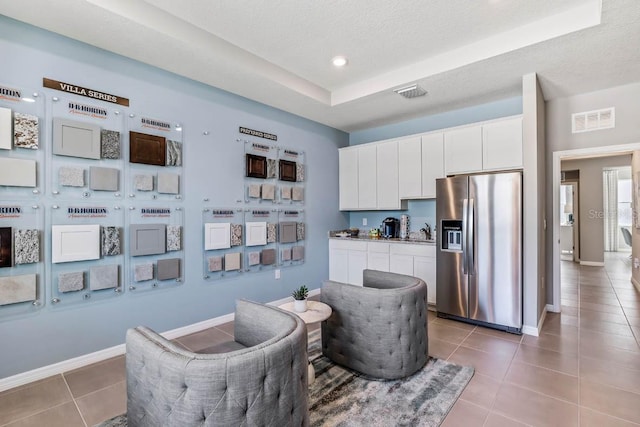 living area featuring a textured ceiling and dark tile patterned flooring