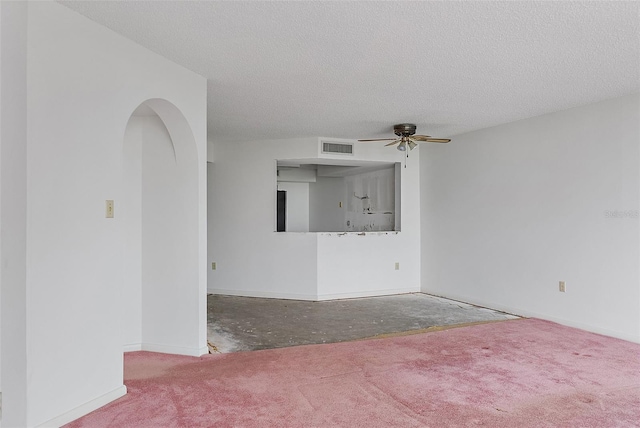 empty room featuring ceiling fan, carpet floors, and a textured ceiling