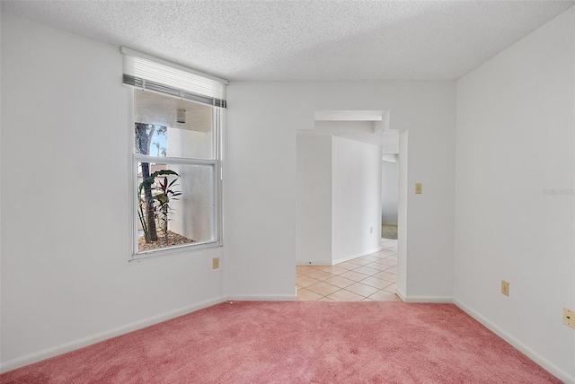 carpeted empty room with a textured ceiling