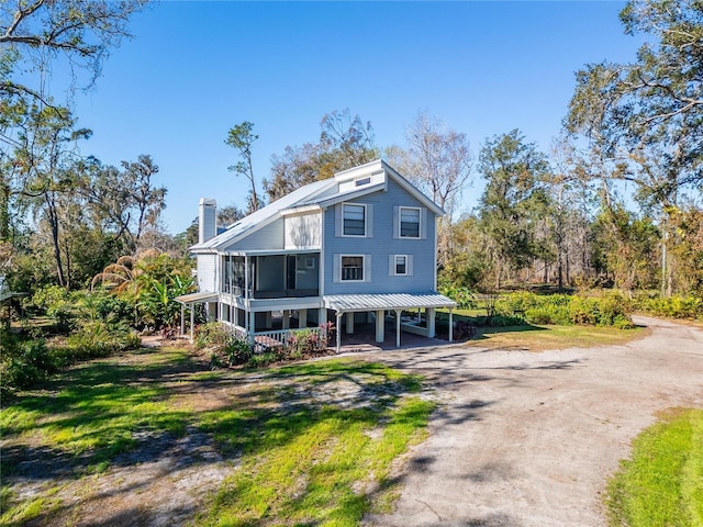 view of front of house featuring a sunroom and a carport