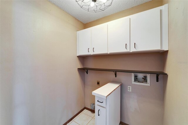 clothes washing area featuring cabinets, washer hookup, light tile patterned floors, a textured ceiling, and hookup for an electric dryer