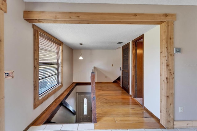 hall with a textured ceiling